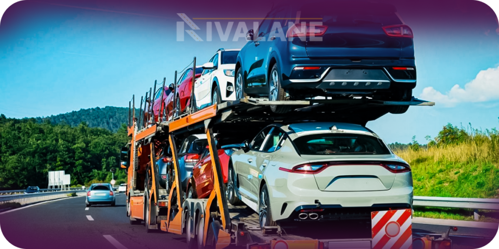 Open car hauler truck transporting multiple vehicles on a scenic highway.