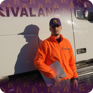 Rivalane auto shipping representative standing in front of transport truck